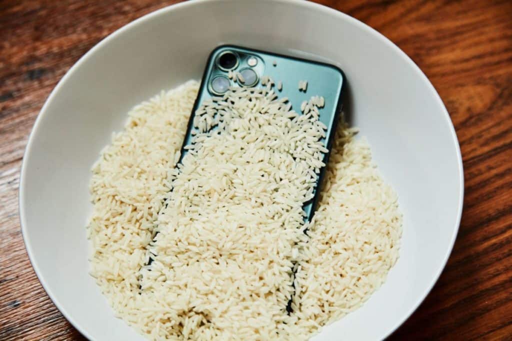 Phone in white bowl filled with rice